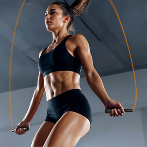 Woman Skipping with the TRNR Elevate Jump Rope with Neon Orange Cable in a Gym