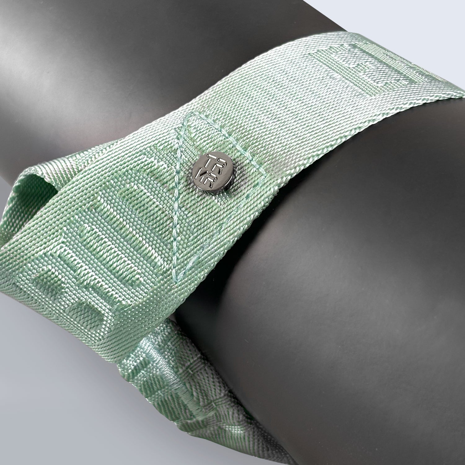 Close-Up of the Mint Mat Carry Strap by TRNR Showcasing the Empowered Mind & Body Mantra and TRNR Logo