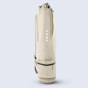 Overview of the TRNR Studio Carry Sack in Oatmeal Showcasing Drawstring Closure, White TRNR Logo, Adjustable Shoulder Strap, and Small Zipper Pocket